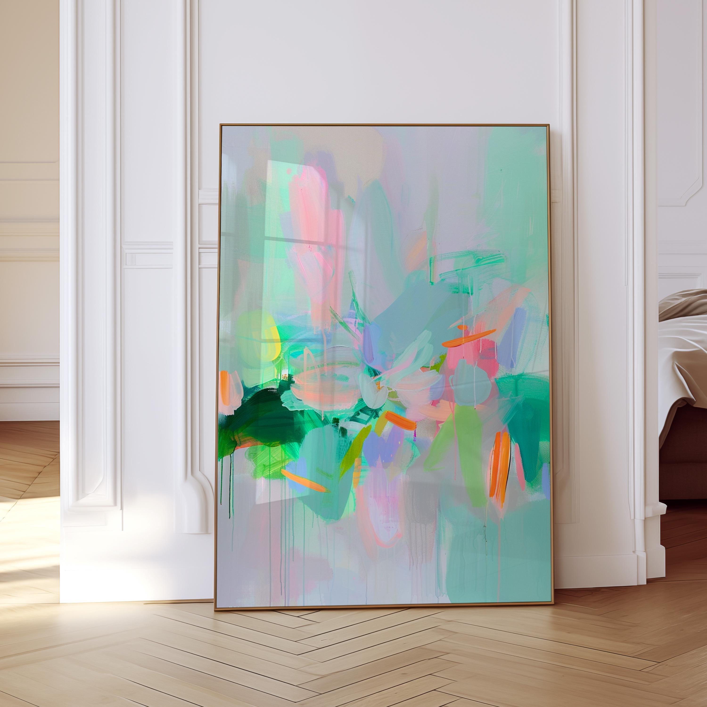 May include: Abstract art print with a gold frame. The artwork features a blend of colors, including pink, green, blue, and orange, creating a vibrant and dynamic composition. The painting is displayed against a light gray background.