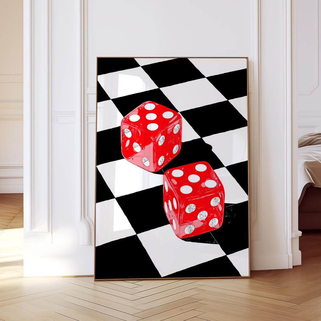 May include: A framed art print featuring two red dice with white dots on a black and white checkered background. The dice are positioned at an angle, creating a dynamic composition. The artwork is displayed in a room with white walls and a wooden floor.