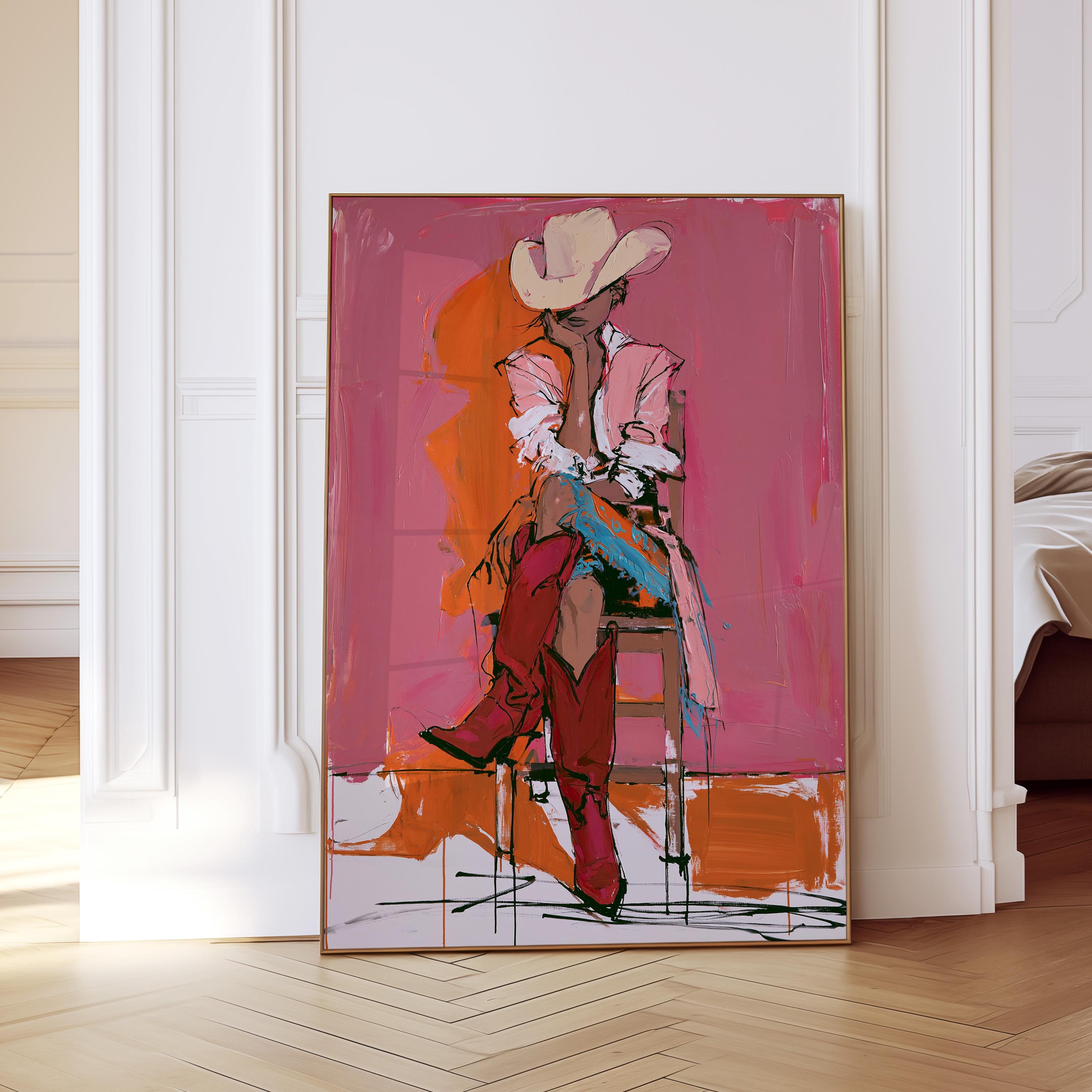 May include: Abstract painting of a person wearing a cowboy hat, pink shirt, and red boots, seated on a wooden chair. The background features pink and orange brushstrokes, framed in a gold border.