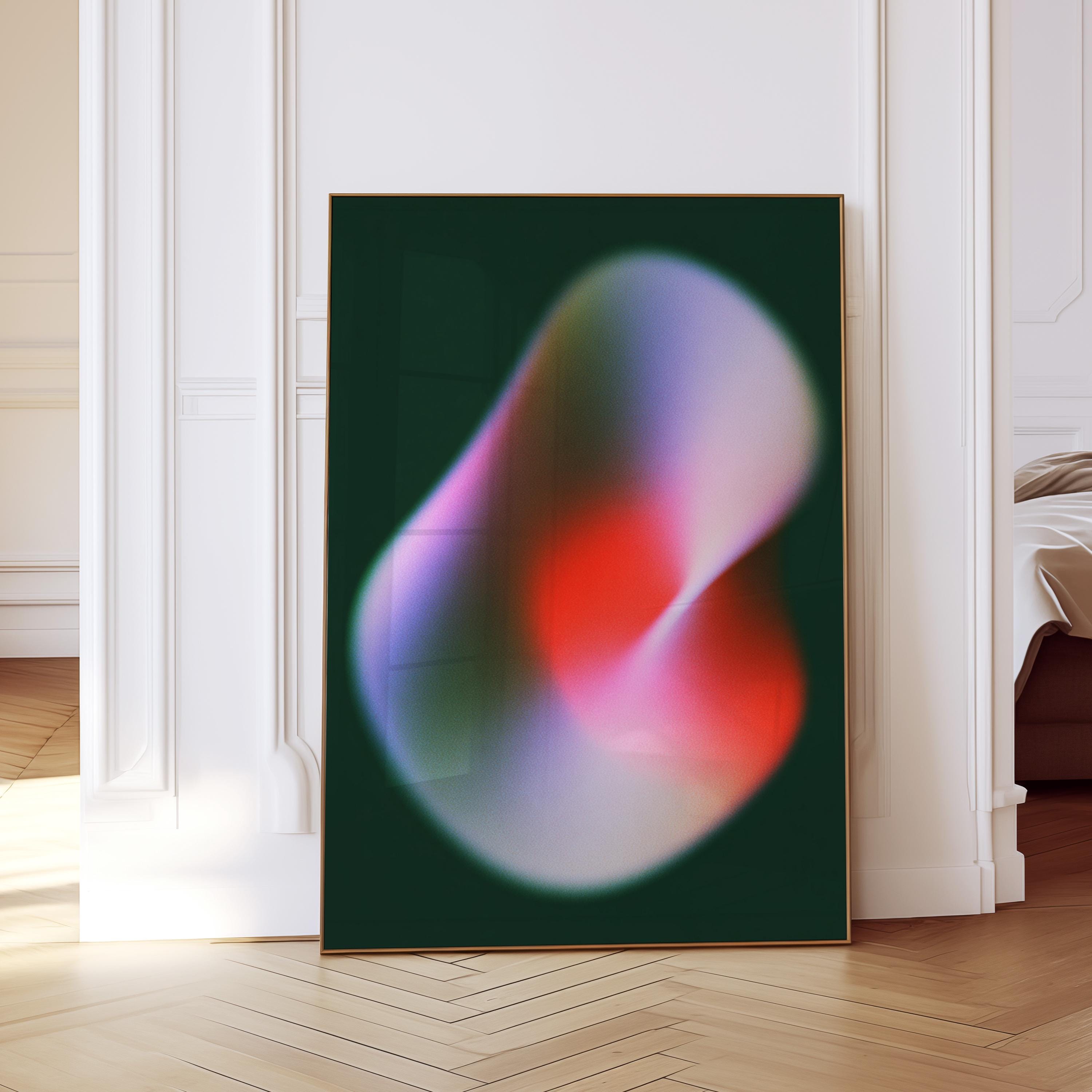 May include: A framed abstract art print featuring a swirling, blurred design. The artwork showcases a gradient of colors, including red, pink, purple, and green, set against a dark green background. The print is displayed in a room with white walls and a wooden floor.