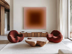 May include: A modern living room featuring two red, rounded armchairs and a unique wooden coffee table. A large, square artwork with a gradient of brown and pink tones hangs above a wooden cabinet. The room has a neutral color palette.