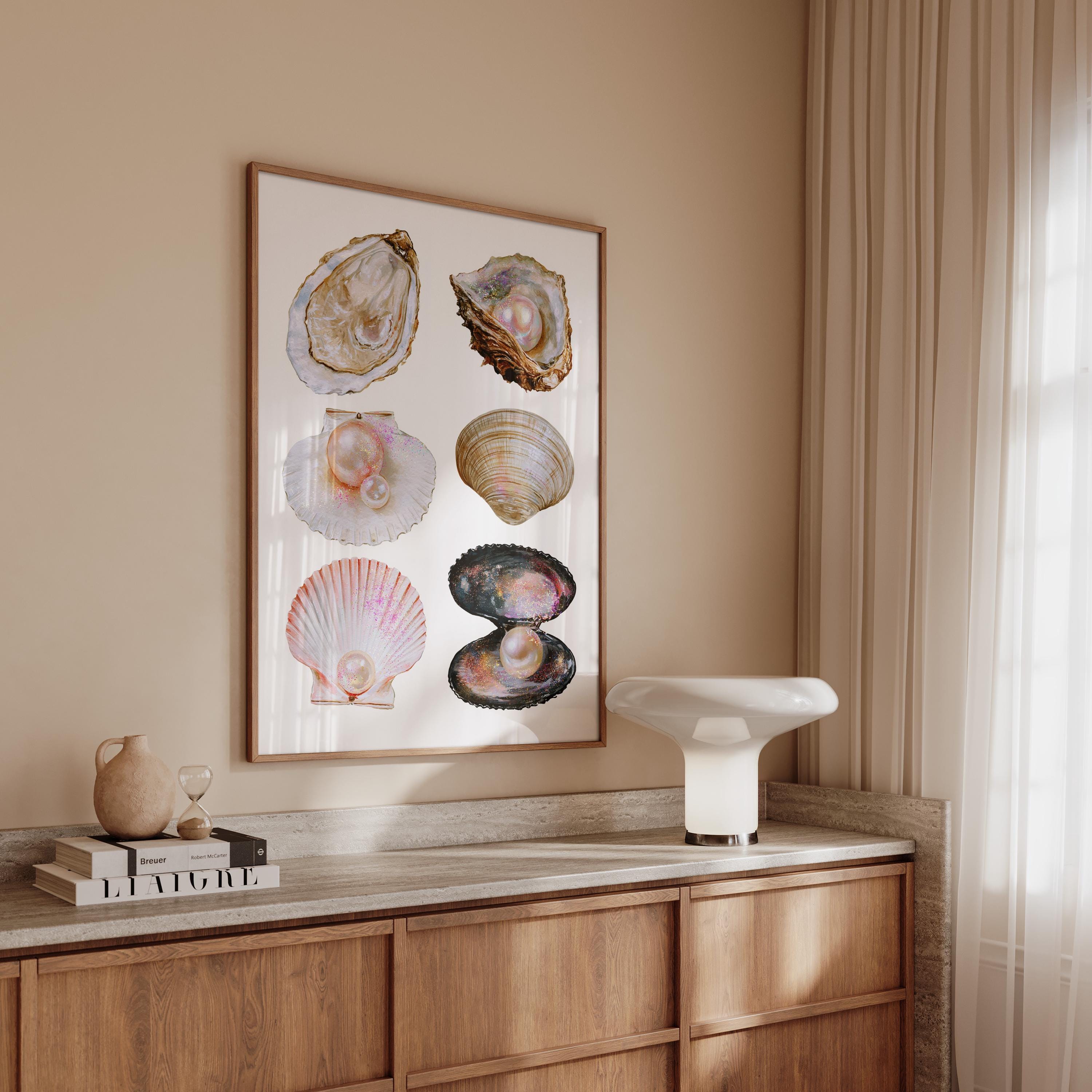 May include: A framed print featuring watercolor illustrations of various seashells, each with a pearl. The shells are in shades of white, pink, brown, and black. The artwork is displayed on a neutral-toned wall.