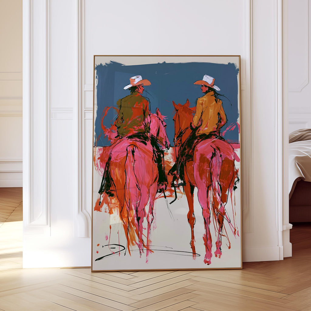 May include: Abstract art print featuring two figures on horseback, rendered in vibrant pink, orange, and green hues. The riders wear cowboy hats and jackets against a blue backdrop. The artwork is framed in a gold-colored frame.
