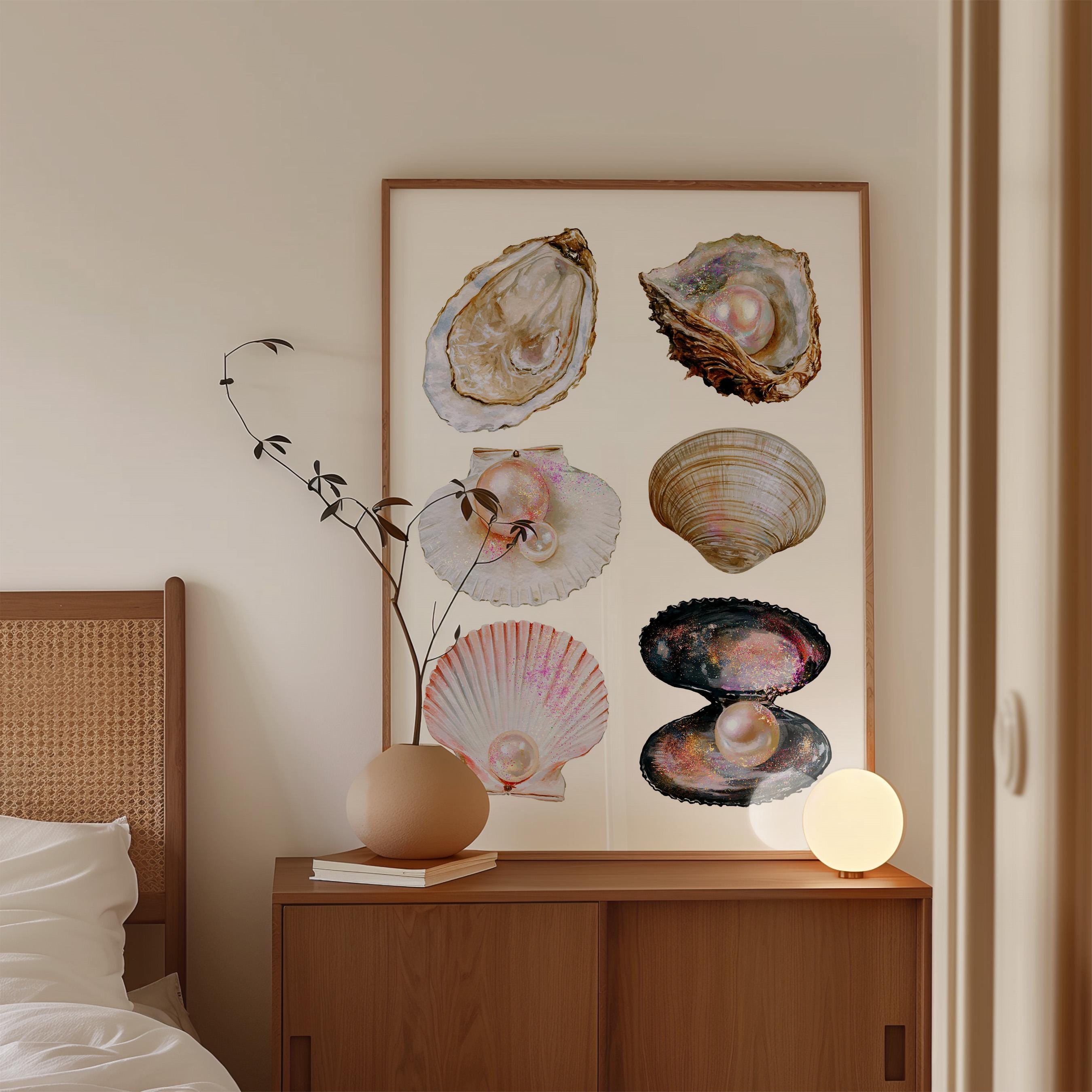 May include: A framed print featuring watercolor illustrations of various seashells, each with a pearl. The shells are in shades of brown, pink, and white, set against a cream background. The artwork is displayed above a wooden cabinet.