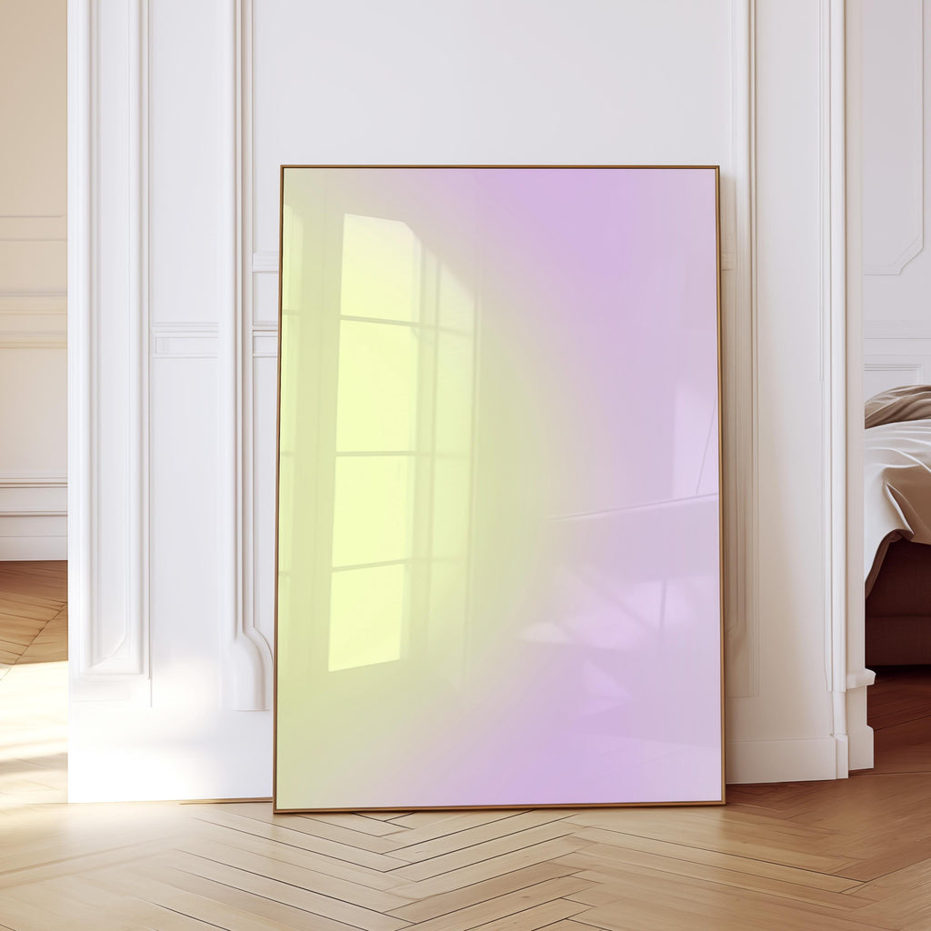 May include: A framed artwork with a gradient of yellow to purple hues. The artwork is displayed in a room with white walls and a wooden floor. The frame is a thin, warm brown color.