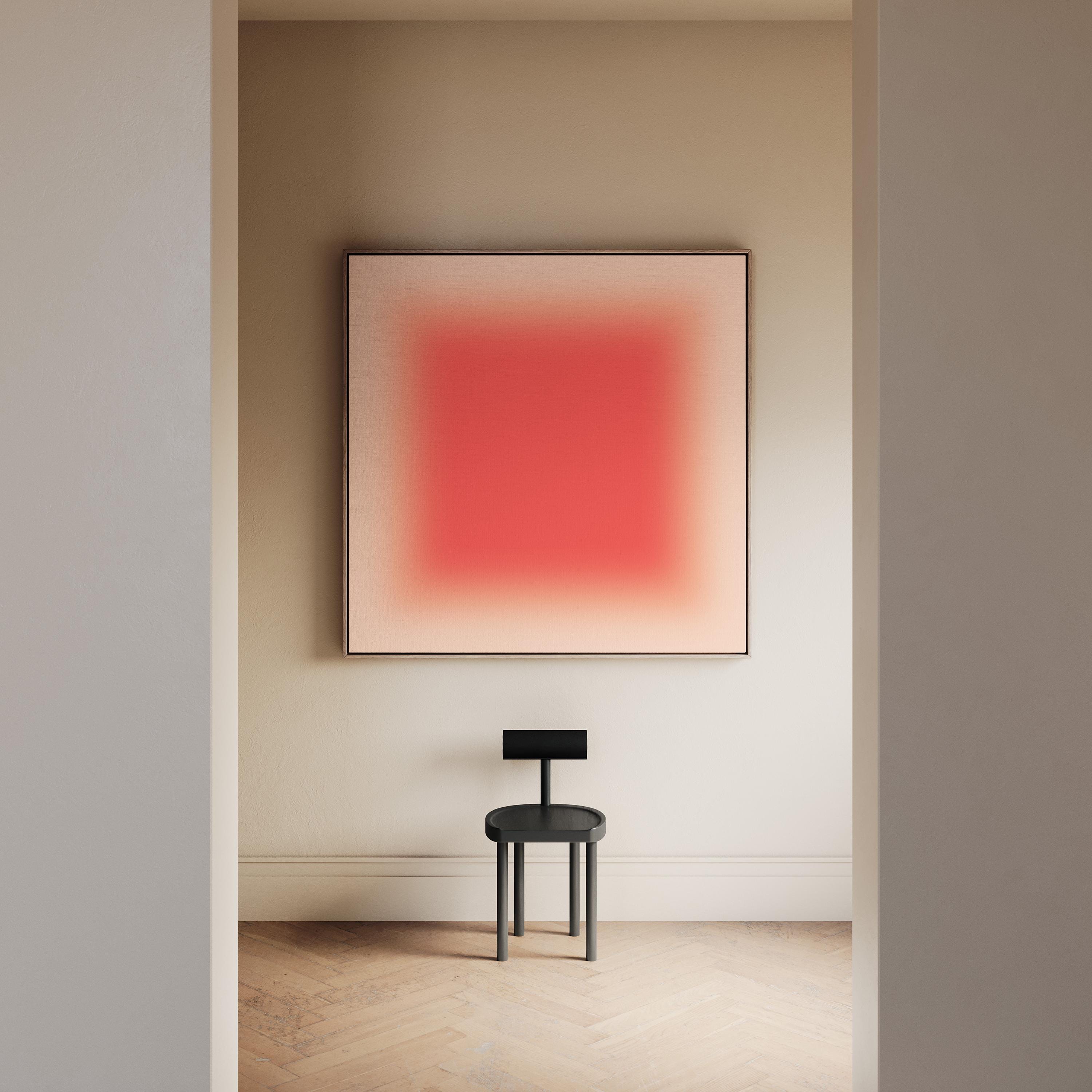 May include: A square wall art piece featuring a vibrant red center that fades into a soft cream border, displayed above a small black stool with a circular seat and a horizontal backrest, positioned in a neutral-toned room setting.