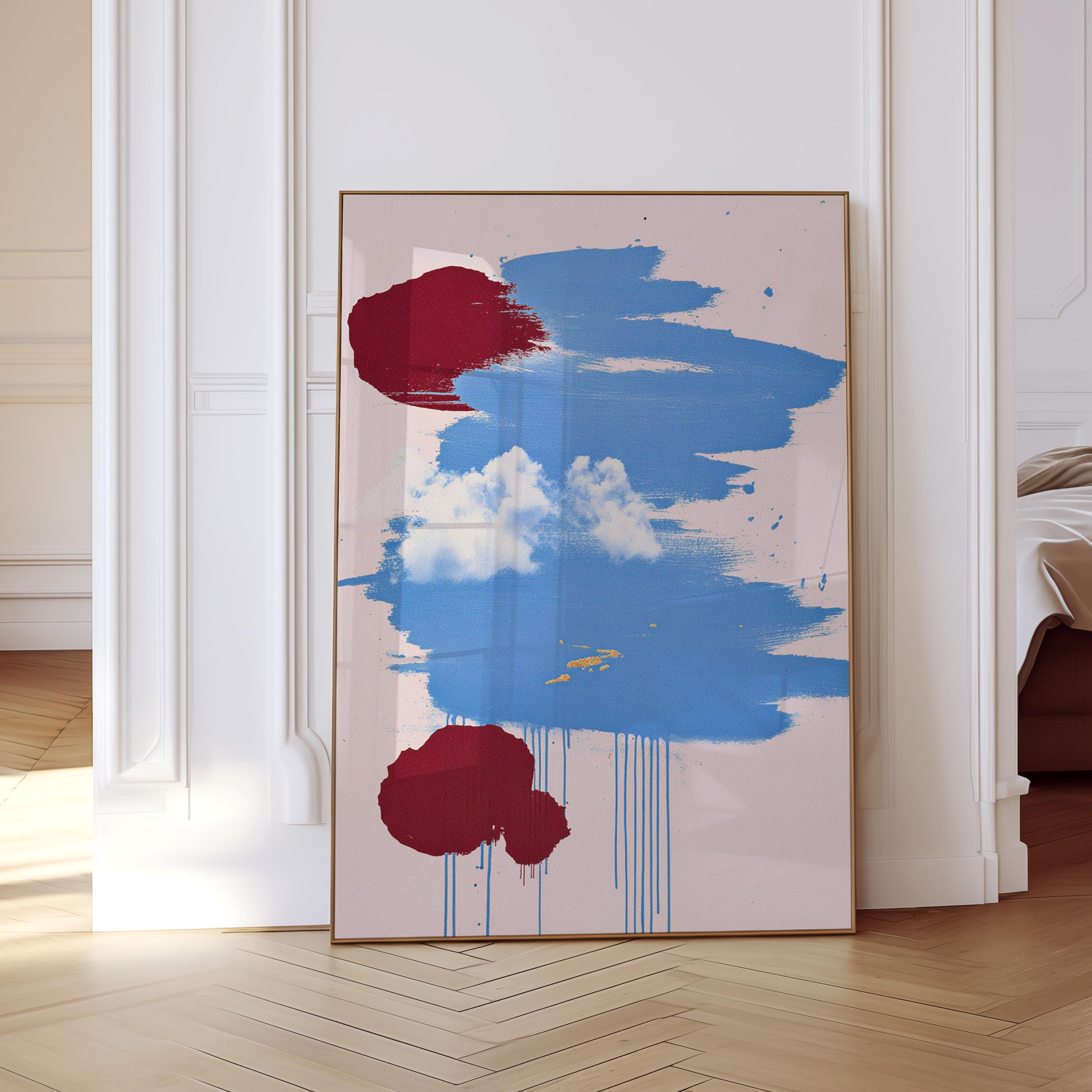 May include: Abstract art print featuring a sky-themed design. The artwork includes a light pink background with blue brushstrokes, red shapes, and a cloud image. The artwork is framed in a thin, brown frame.