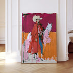 May include: Abstract art print of a person in a cowboy hat and red coat, standing next to a pink horse. The artwork features bold brushstrokes and a vibrant color palette of pink, orange, and blue.