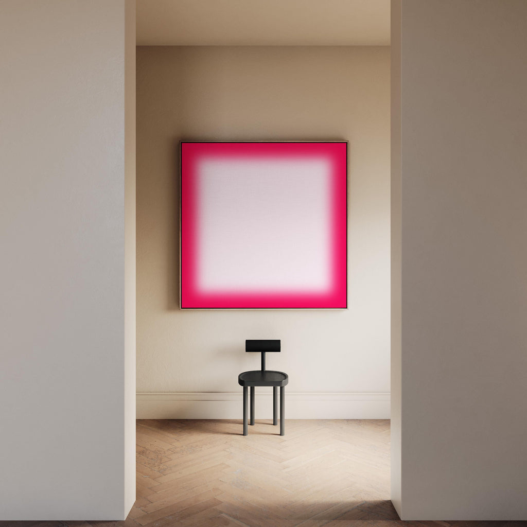 May include: A modern interior scene featuring a large square artwork with a vibrant pink gradient border and a white center. A small black chair sits below the artwork. The room has light-colored walls and a wooden floor.