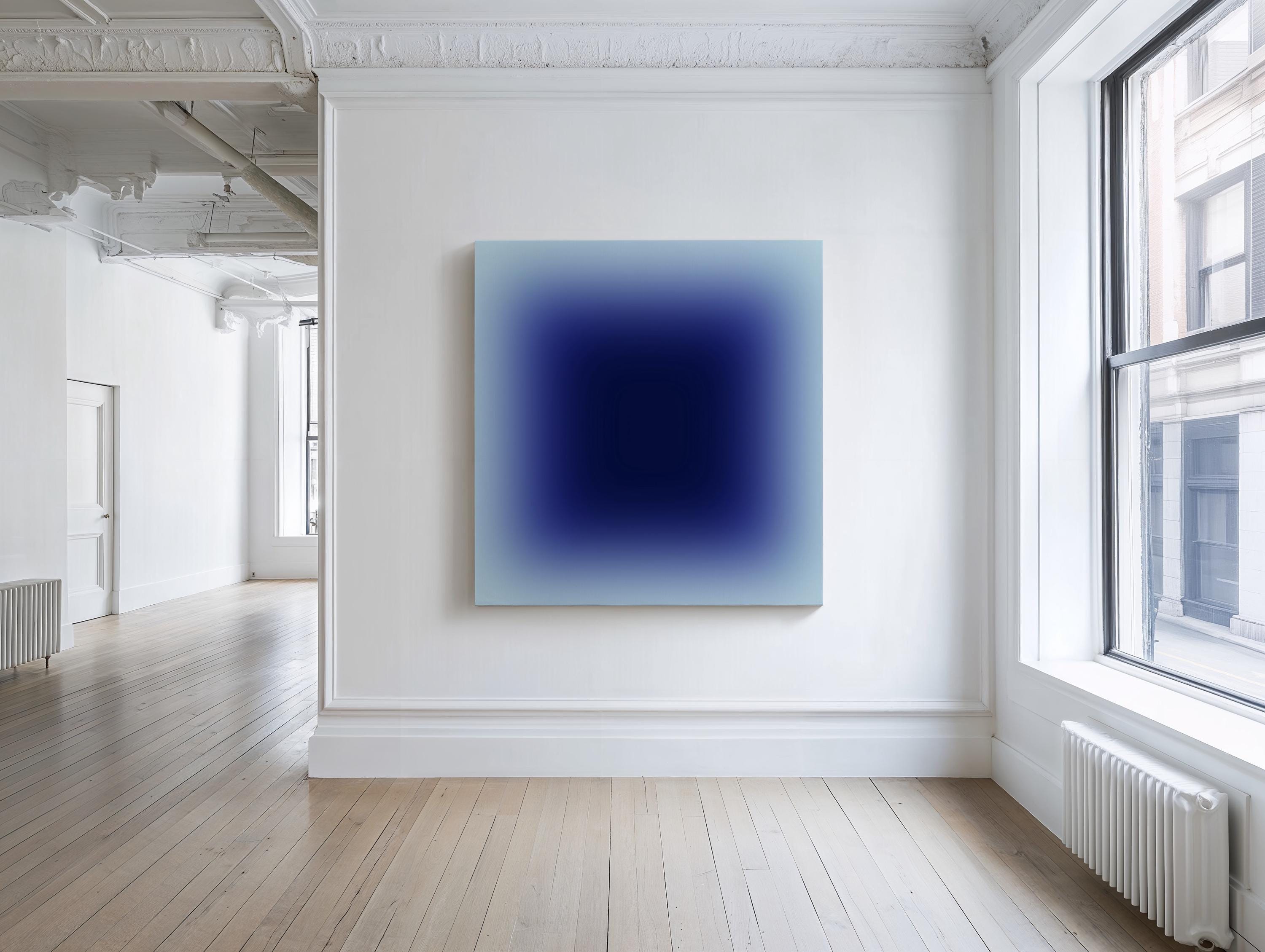 May include: A large, square abstract painting with a gradient of blue hues, from light blue edges to a deep navy center, hangs on a white wall. The artwork is the focal point in a bright, minimalist room with wooden floors and a window.
