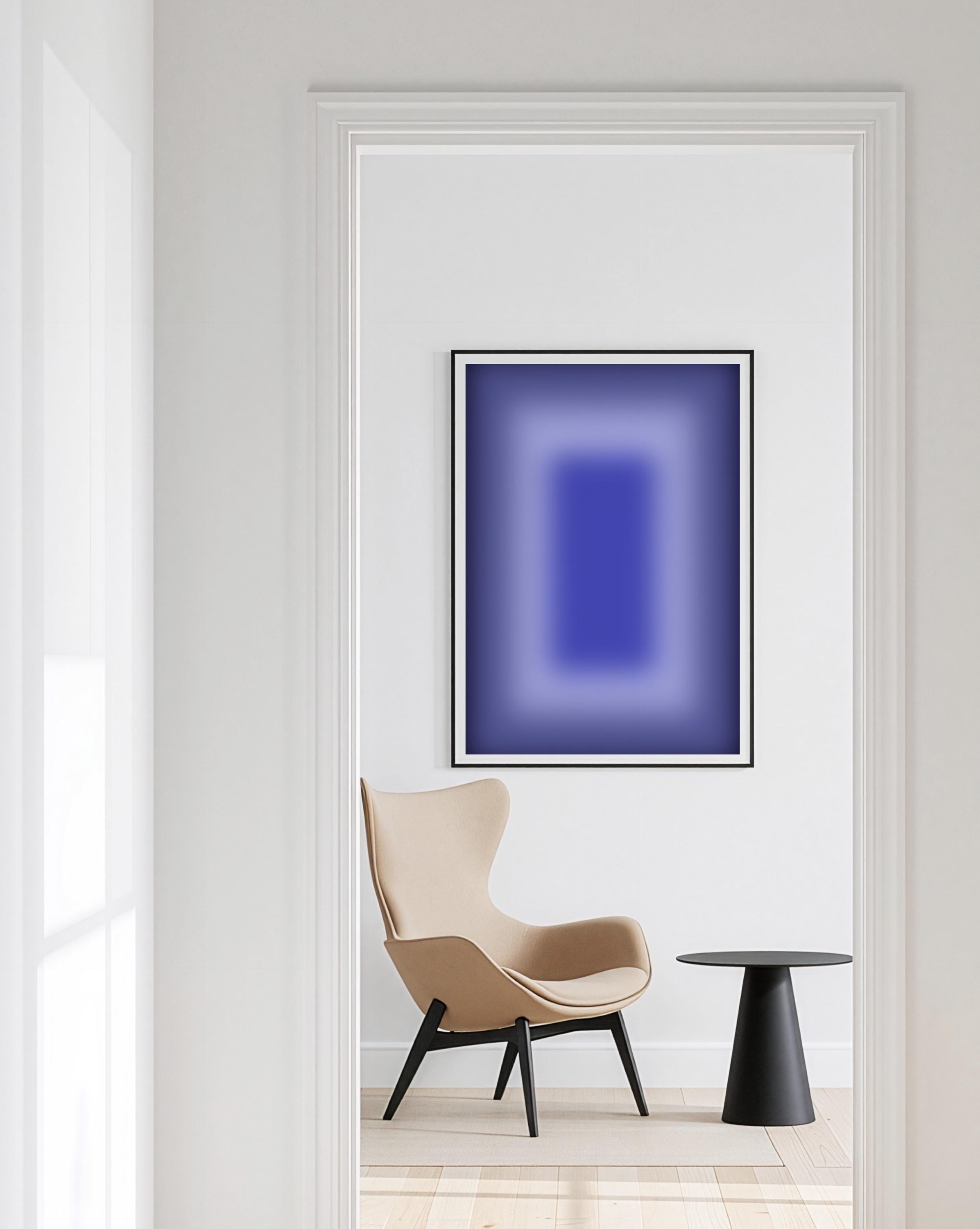 May include: A framed abstract art print with a gradient of blue hues, from dark to light, hangs on a white wall. A beige armchair and a small black side table are in the foreground, creating a minimalist interior design.