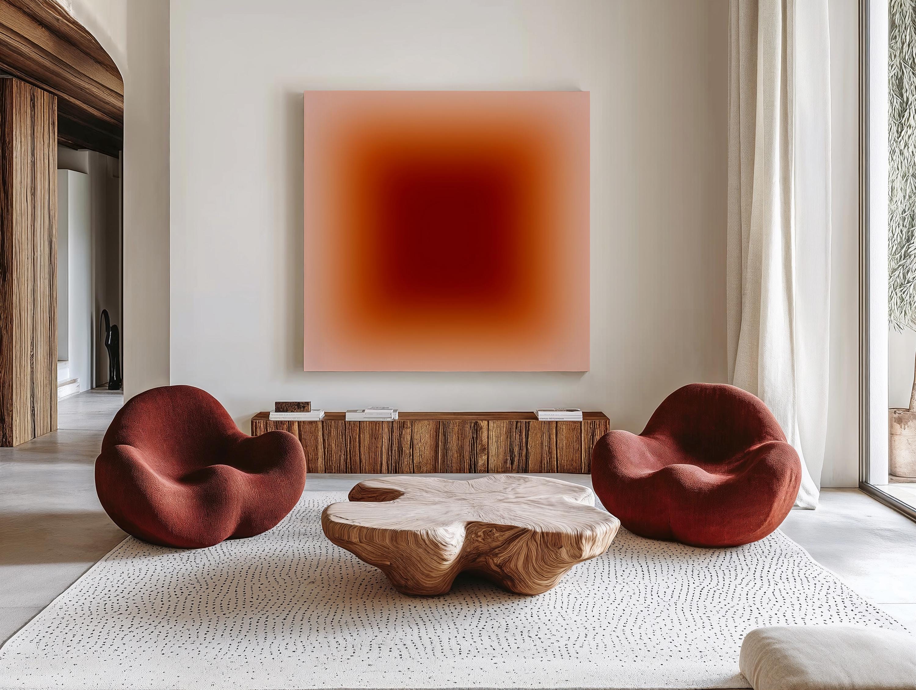 May include: A modern living room featuring two red, rounded armchairs and a unique wooden coffee table. A large square painting with a gradient of red and pink hues hangs above a wooden cabinet. The room is decorated with a neutral-colored rug.