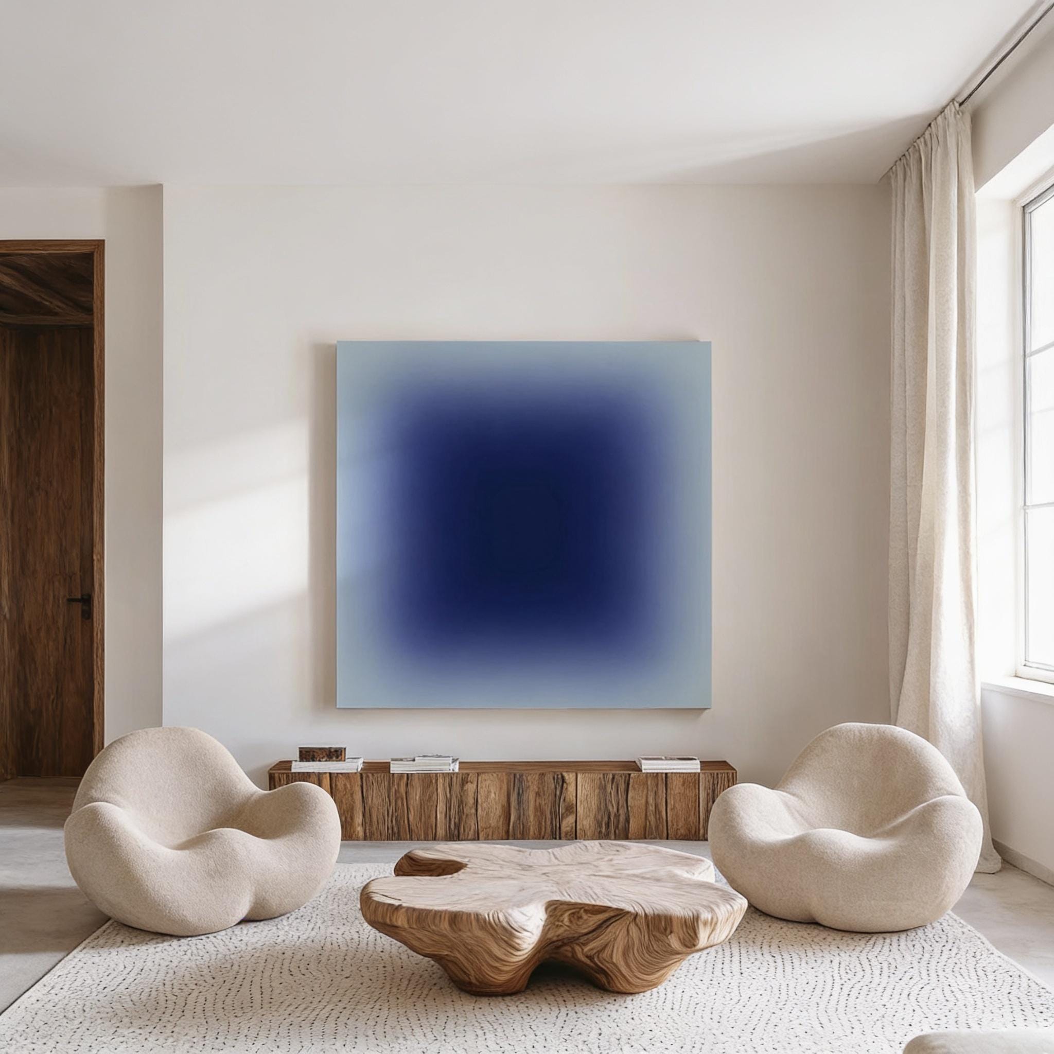 a modern living room with a large blue square artwork hanging on the wall. The room is furnished with two white armchairs and a wooden coffee table, creating a cozy and inviting atmosphere.