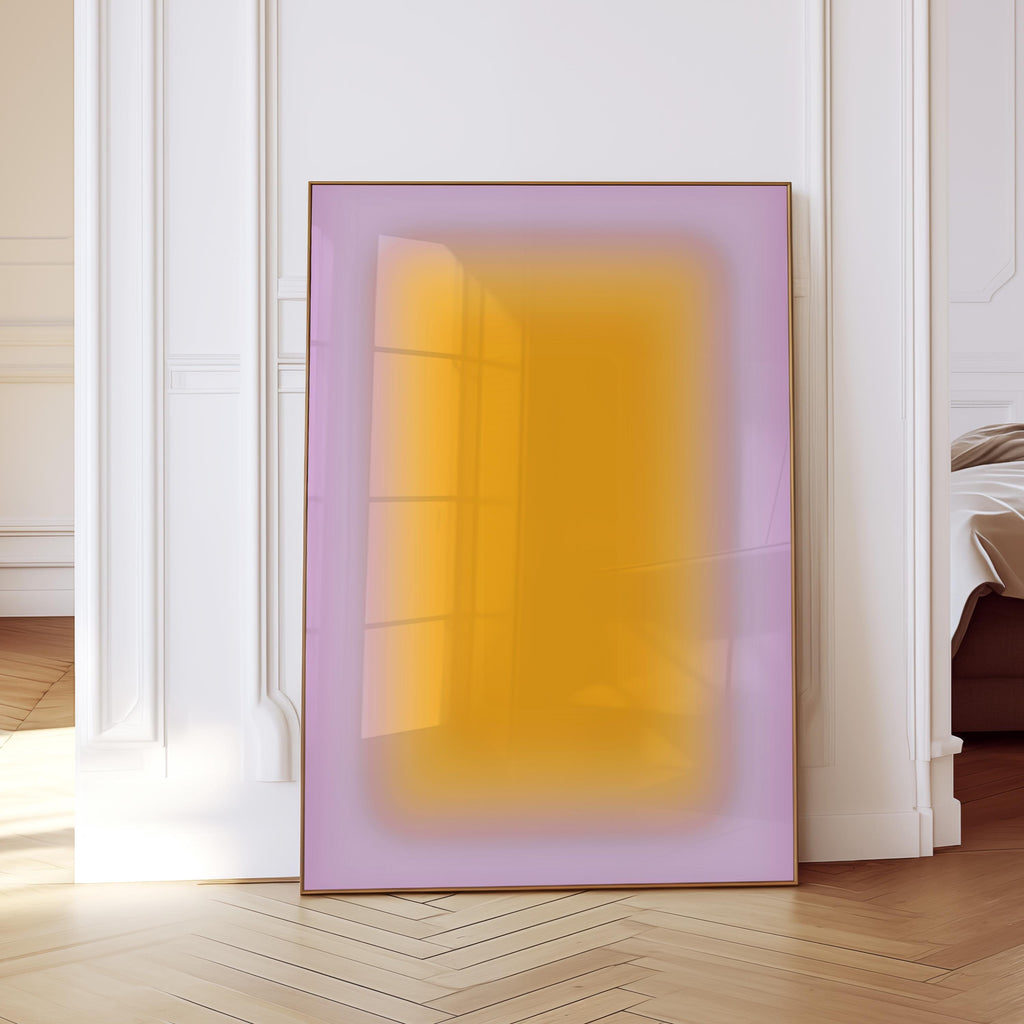 May include: A framed abstract art print featuring a gradient of colors. The artwork has a rectangular shape with a soft, blurred transition from a lavender border to a bright yellow center. The frame is a thin, dark brown color.