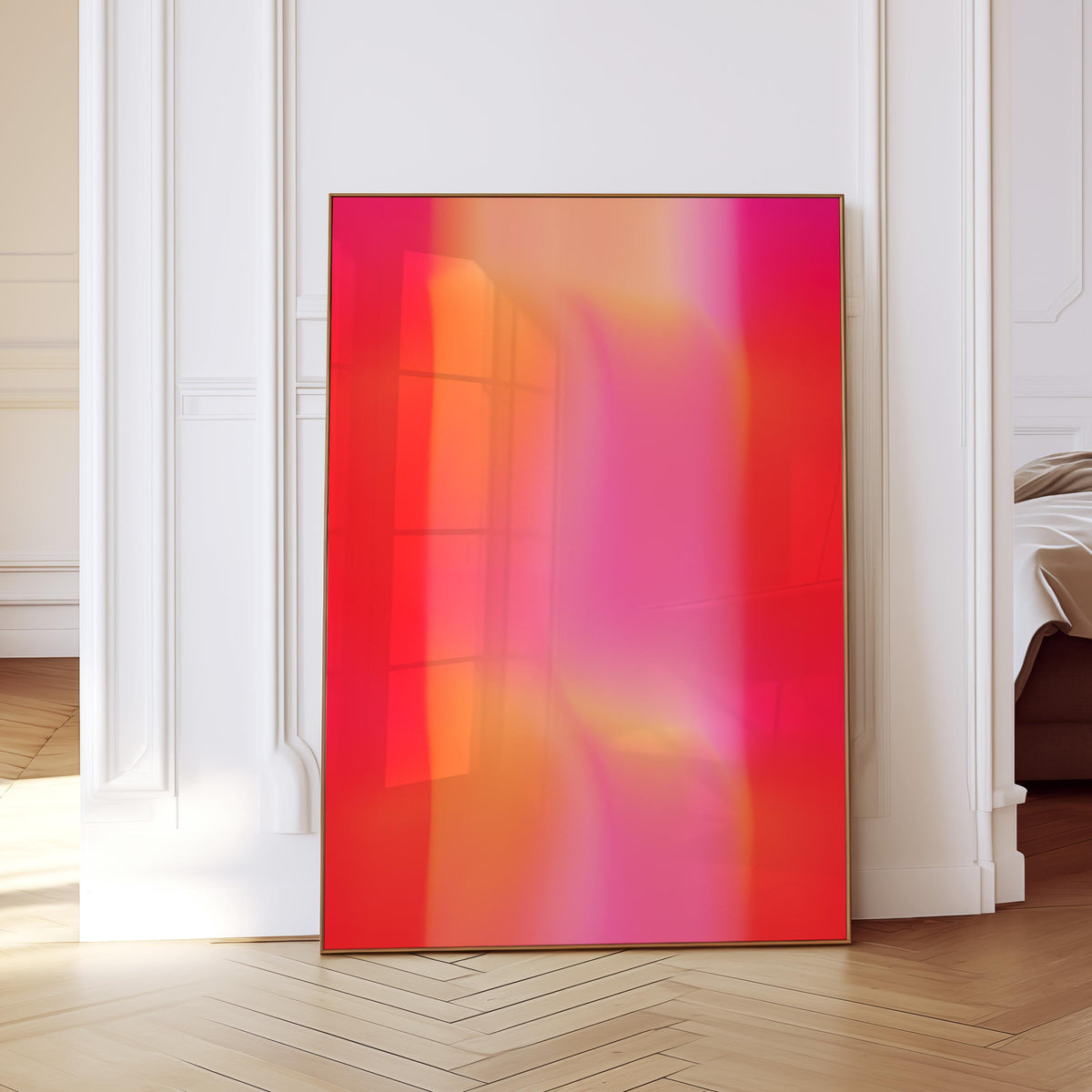 May include: A framed abstract art piece with a vibrant gradient of red, orange, and pink hues. The artwork is displayed against a white wall and a light-colored wooden floor. The frame is a thin, gold color.