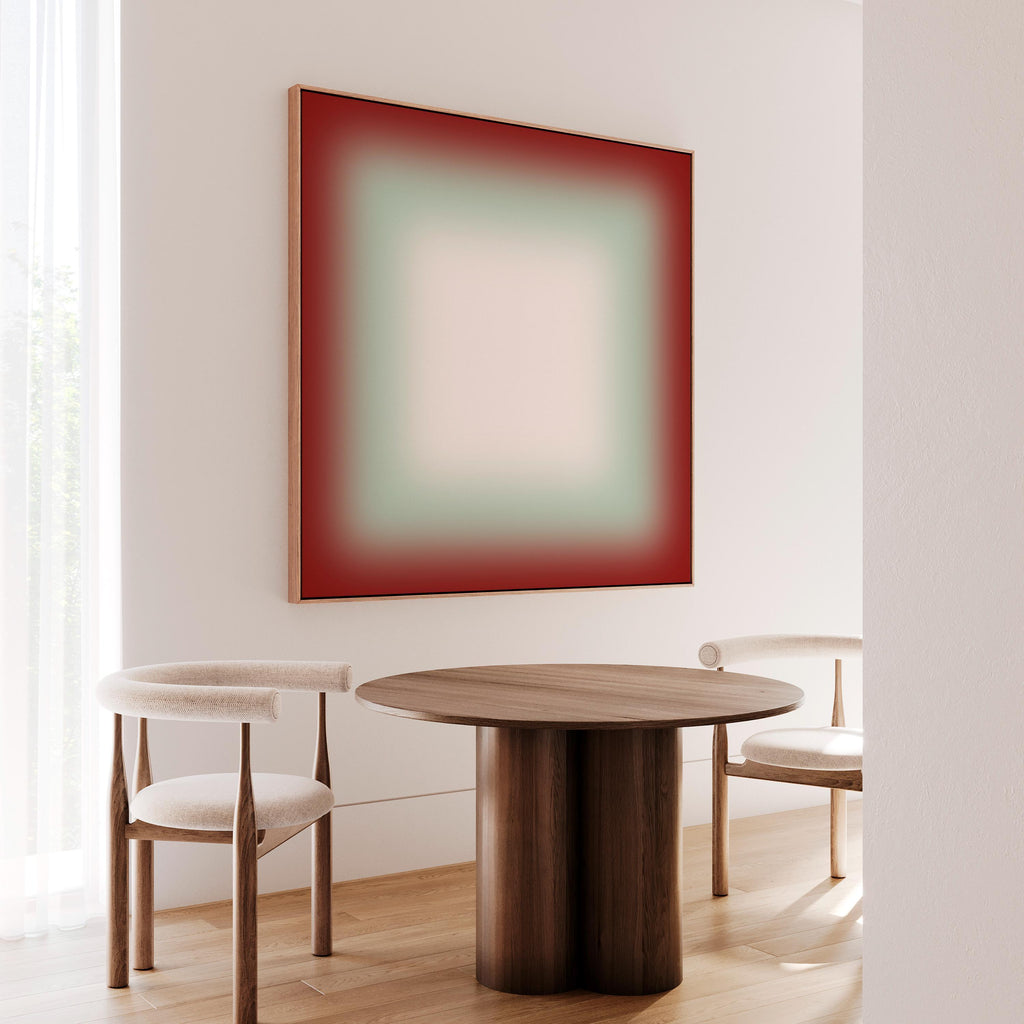 a modern dining area with a wooden table and two white chairs. Above the table, there is a large abstract painting in red and green colors. The room has a minimalist and clean design, with white walls and a wooden floor.