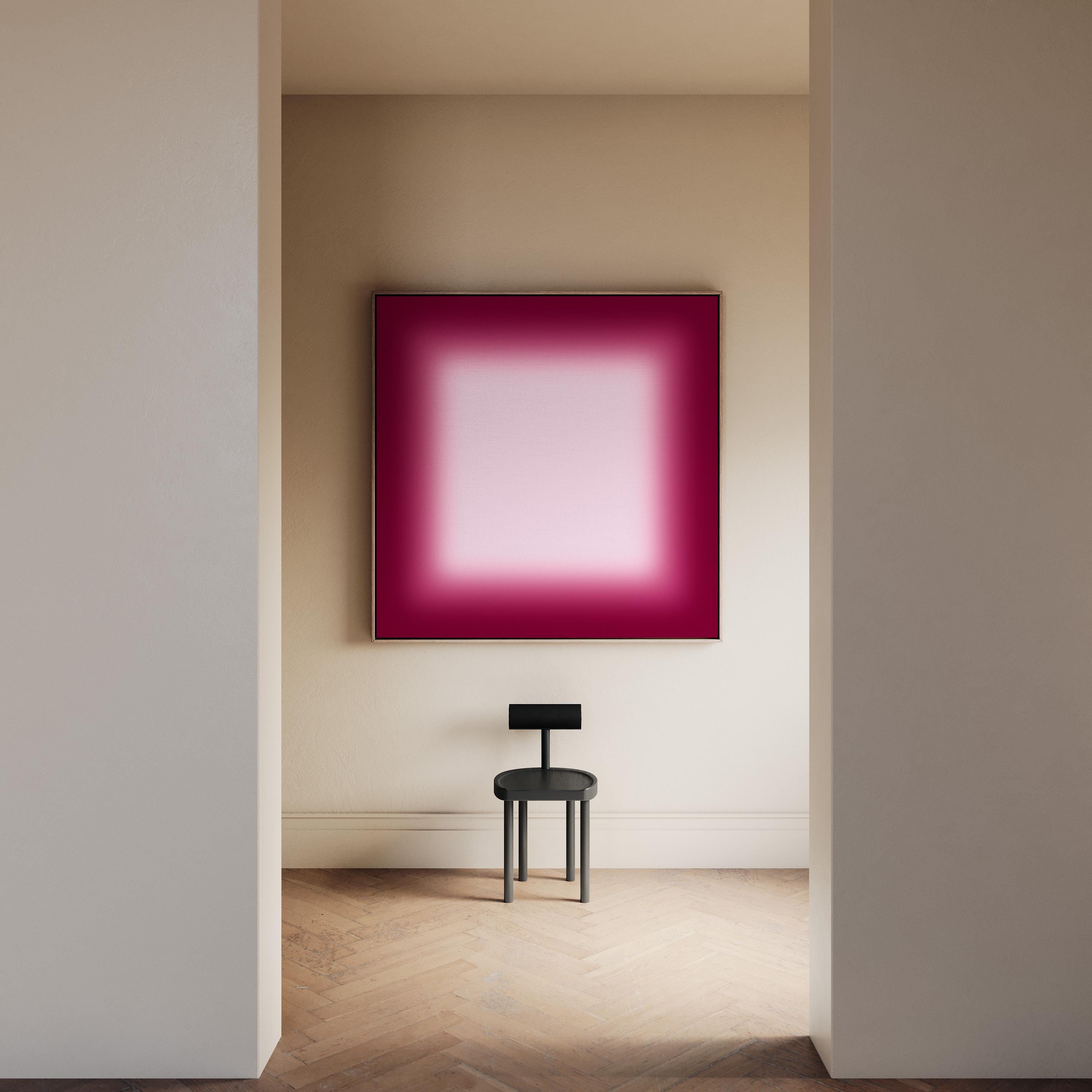 May include: A modern interior scene featuring a large, square artwork with a gradient of pink and magenta hues. A small, black chair sits below the artwork. The room has beige walls and a light wood floor.