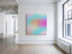 May include: Square canvas art with a soft, blurred gradient of colors including pink, orange, blue, and yellow. The text "everything comes down my side" is written in white script. The artwork hangs on a white wall in a bright room.