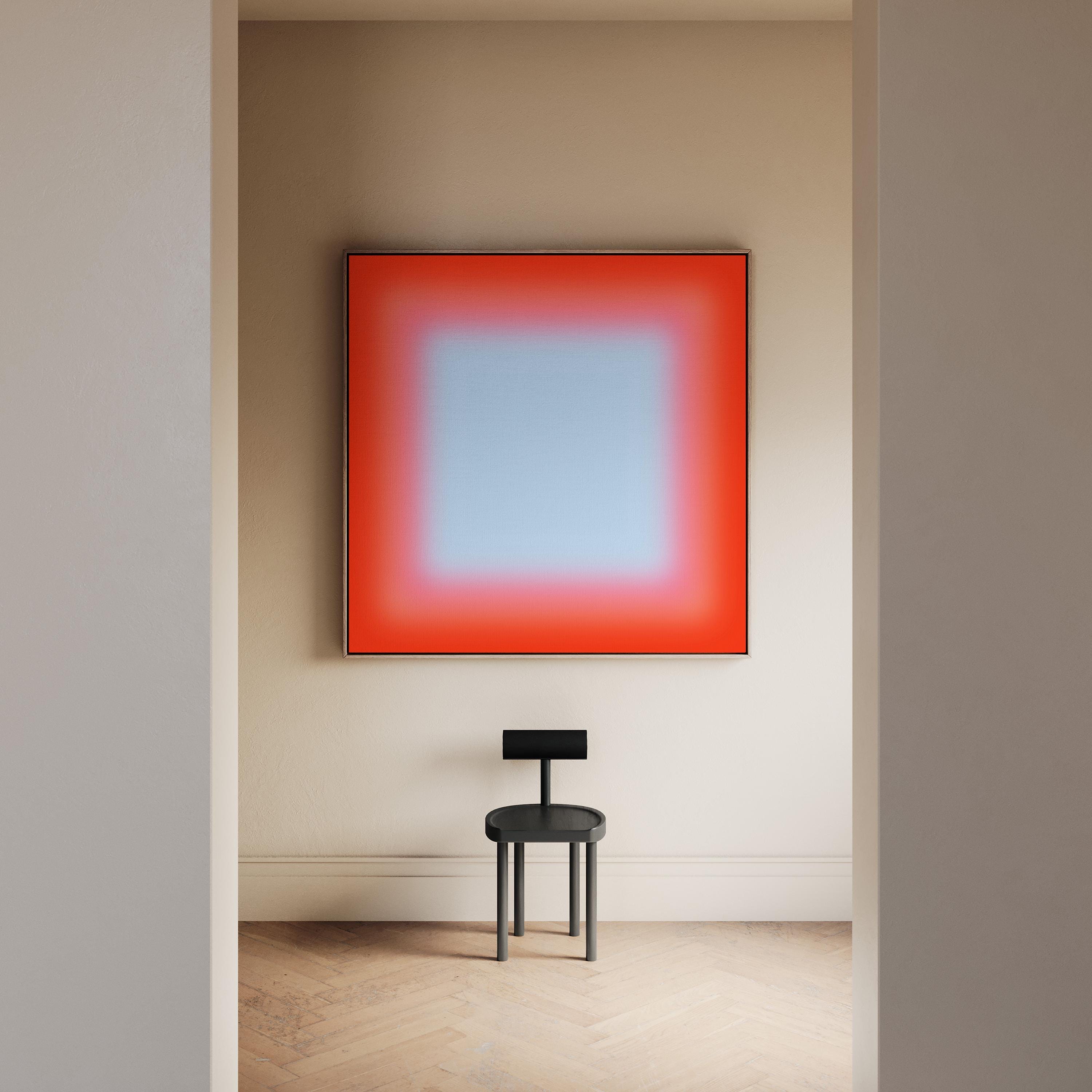 May include: A modern interior scene featuring a large square artwork with a gradient of red to blue hues. Below the artwork is a small, black, minimalist chair. The room has light-colored walls and a wooden floor.