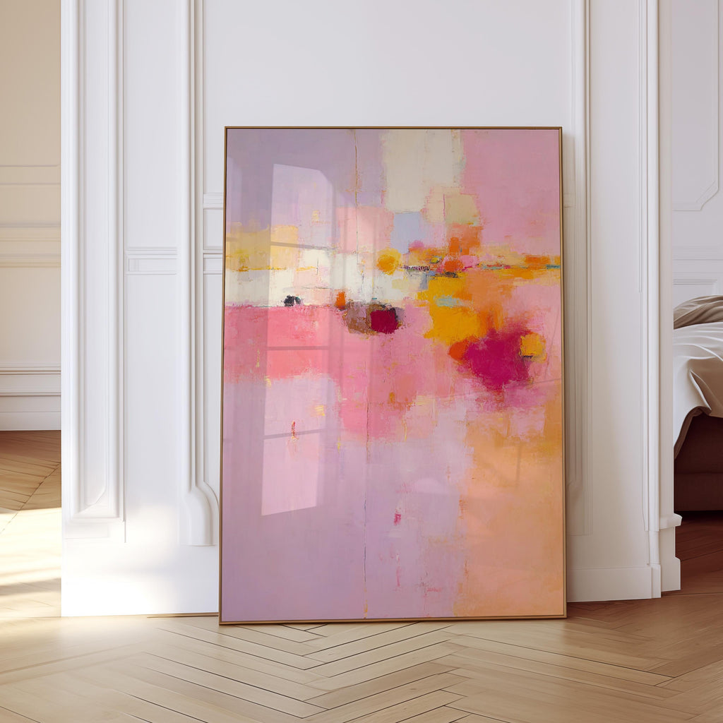 May include: Abstract art print in a wooden frame. The artwork features a blend of pink, purple, orange, and yellow hues. The composition includes brushstrokes and color blocks, creating a modern and vibrant aesthetic. The framed art is leaning against a white wall.