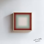 A square, abstract painting with a gradient of red and green colors, hanging on a white wall.