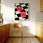 May include: A framed art print featuring two red dice with white dots against a black and white checkered background. The dice appear to be floating. The artwork is displayed in a kitchen setting with a wooden chair and cabinets.