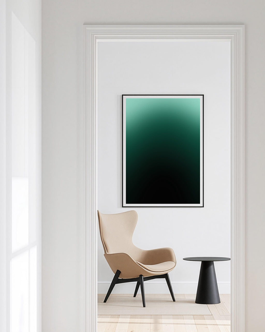 May include: A framed art print with a gradient of teal to black hangs on a white wall. A beige armchair with black legs and a small black side table are in the foreground. The room is framed by a white doorway.