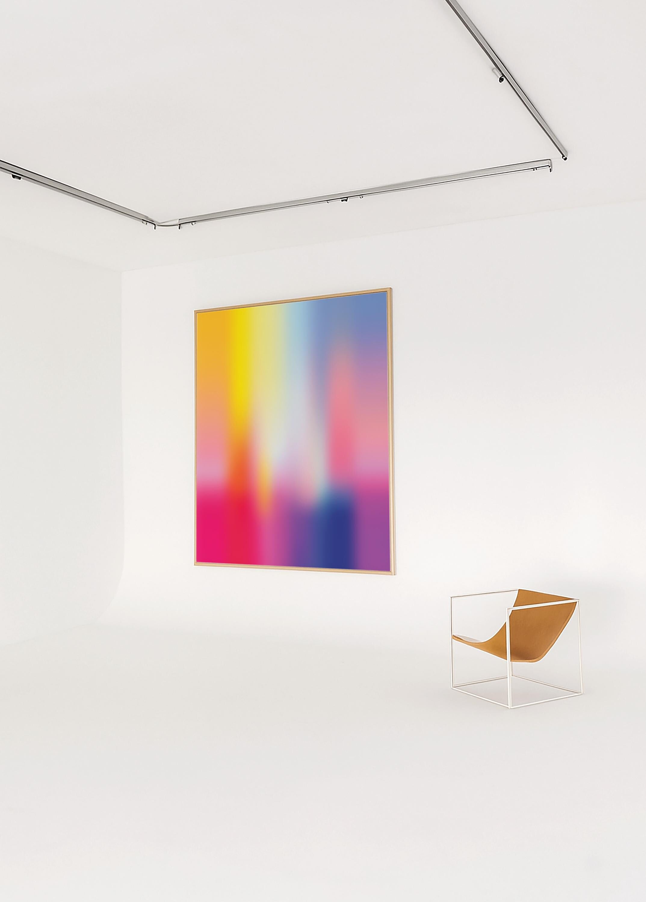 May include: A large framed abstract art piece with a vibrant color gradient of yellow, pink, and blue hues. A modern chair with a white metal frame and tan leather seat sits nearby. The artwork is displayed in a white room.